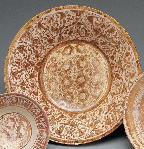 COUPE AU DÉCOR VÉGÉTAL TAPISSANT Coupe tronconique, décorée en lustre métallique brun sur glaçure opaque blanche de fleurons cruciformes et palmette