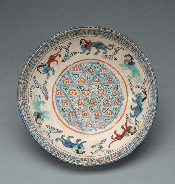 COUPE AUX SPHINGES Coupe hémisphérique de type « minaï », décorée au petit feu de sept sphinges passant autour d'un rondeau tapissé d'un réseau de motifs géométrique