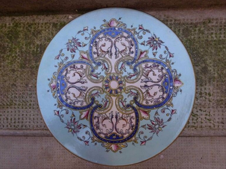 COUPE circulaire plate en faïence à décor émaillé polychrome dans le goût chinoisant d'une rosace centrale, de quatre lobes et de rinceaux feuillagés et fleuris de lotus, l'ensemble sur un fond bleu clai