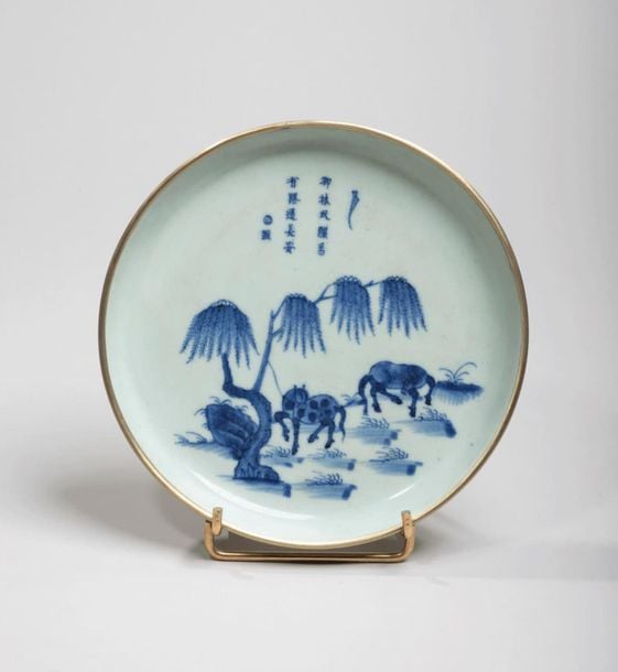 Coupe en porcelaine à décor en bleu sous couverte de deux chevaux paissant sous un saul