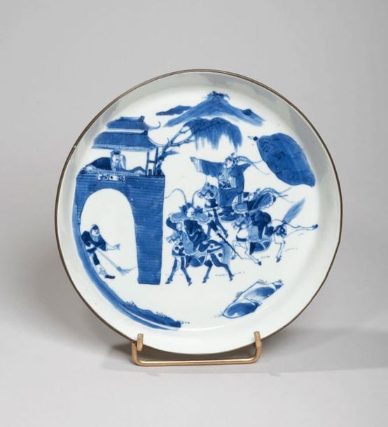 Coupe en porcelaine à décor en bleu sous couverte de guerriers à cheval près d'une port
