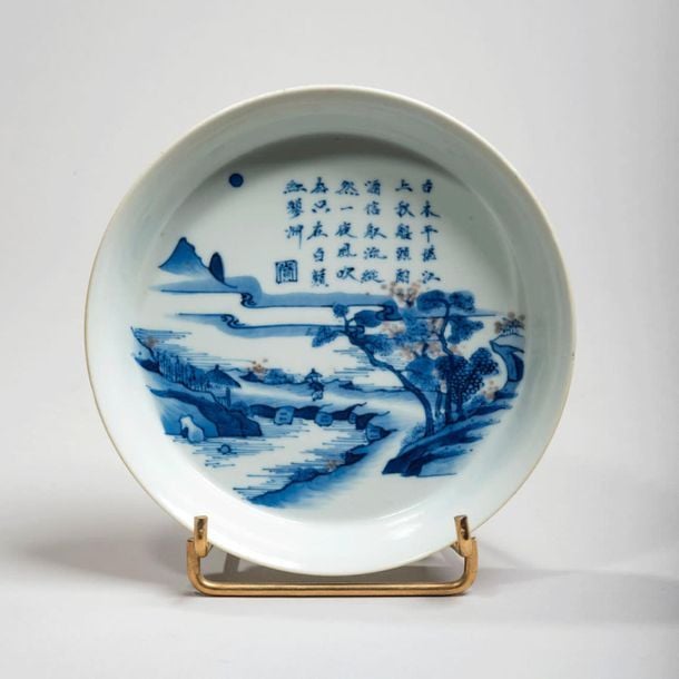 Coupe en porcelaine à décor en bleu sous couverte et rouge de fer de paysage lacustre et poèm
