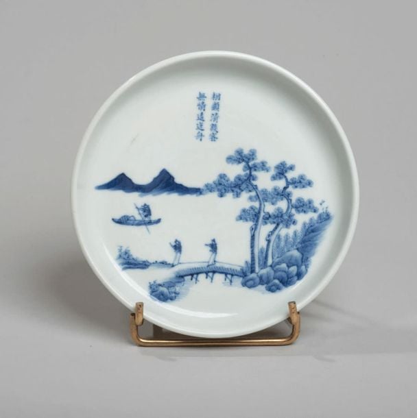 Coupe en porcelaine décorée en bleu sous couverte de deux lettrés sur une rive et d'un pêcheur en barque avec poèm