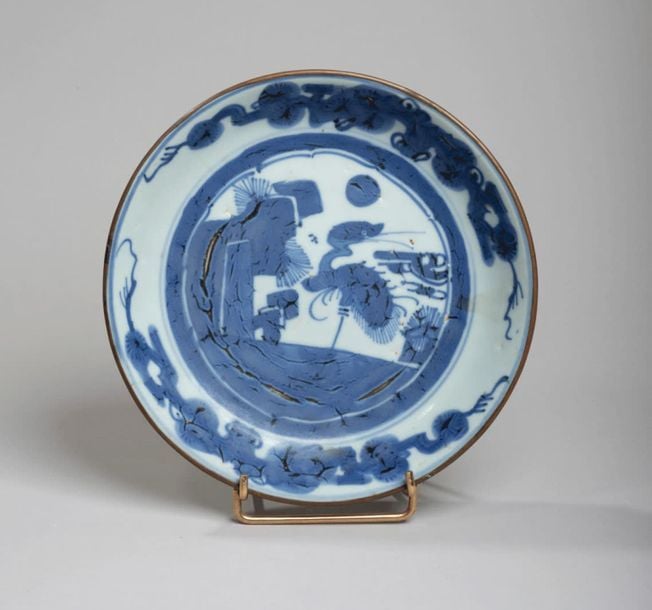 Coupe en porcelaine décorée en bleu sous couverte de grues au centre entourée de pin