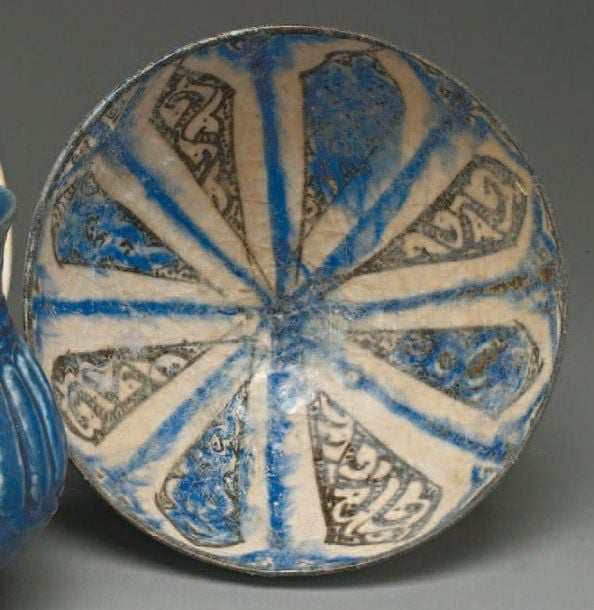 COUPE RAYONNANTE Coupe convexe, décorée sur fond blanc de pétales rayonnants bleus et noirs, séparés par huit lignes bleue