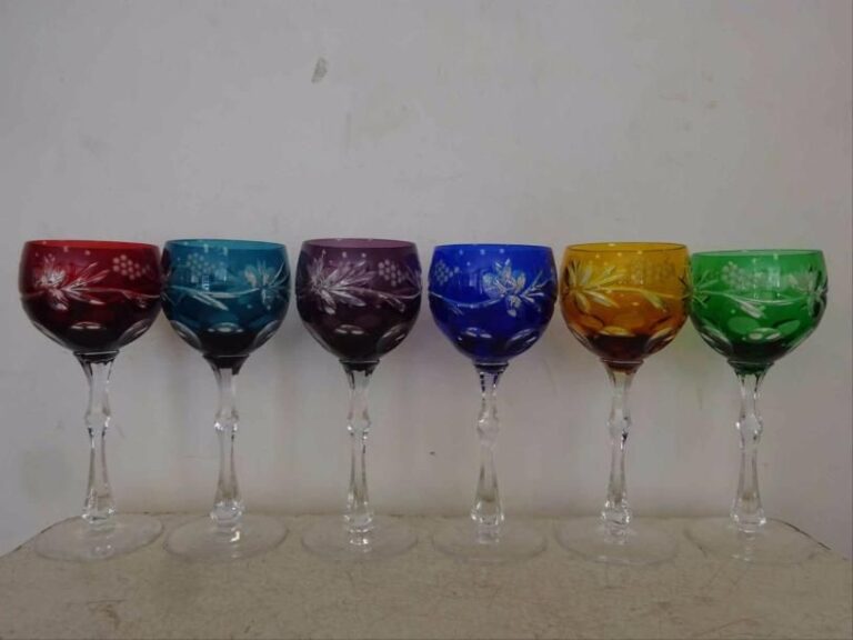 CRISTAL DE PARIS Lot de six verres à pied en cristal coloré taillé à la meule à décor de fleurs et de raisins, les jambes balustres à pans coupé