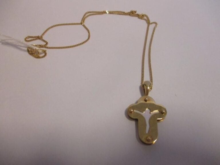 Croix en or jaune 18K (750°/00) ajourée et ornée d'une plaque de nacr