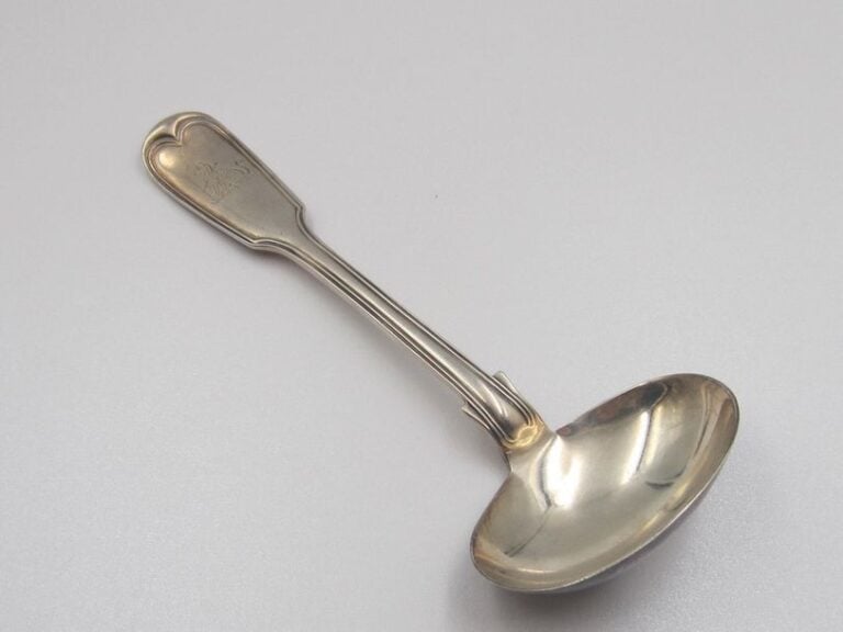 Cuillère à sauce en argent (minimum 800 millièmes), modèle filet ; la spatule gravée à l'anglaise d'un félin transpercé d'une flêch