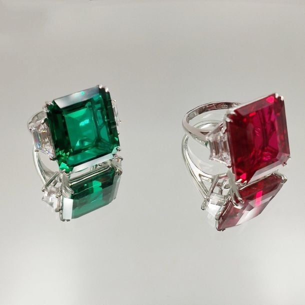 •Deux BAGUES en or gris (585‰) 14 carats serti de pierres blanches, verte et rouge d'imitation, taillées à degré