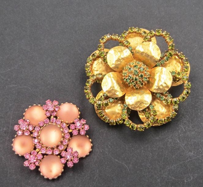 Deux broches fleurs: l'une en métal doré et martelé ornée de pierres vertes, l'autre ornée de pierres rose