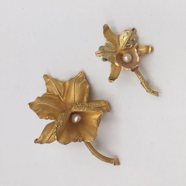 Deux BROCHES «orchidée» en or jaune et or rose (750 millièmes) sculpté, amati et ciselé, centrées de perles de culture blanche