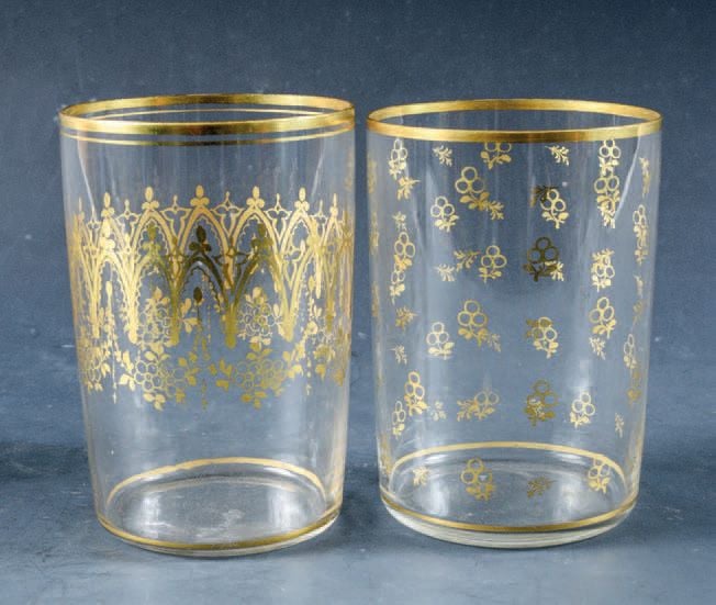 Deux gobelets droits en cristal mince, l'un à décor doré d'arcature gothique et de fleurettes, le second à semis de fleurettes et feuillages stylisé