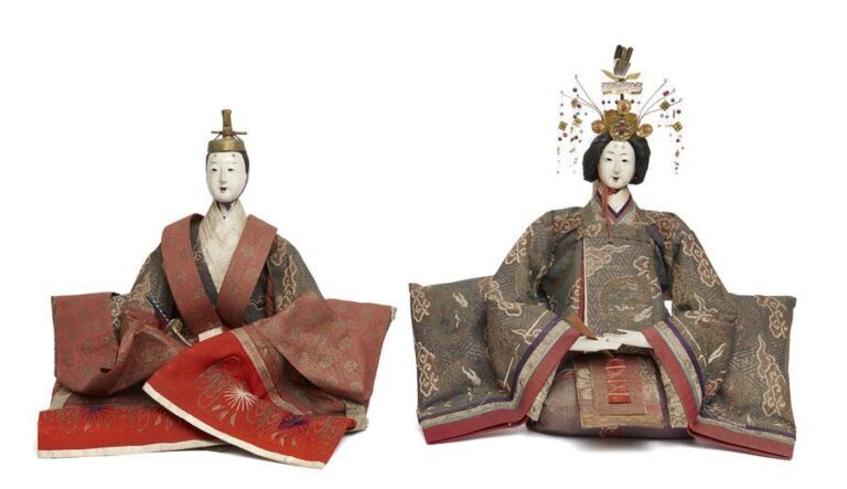 Deux grandes vieilles poupées ningyo pour le festival de poupée (hinamatsuri): l'impératrice et l'empereur sont assis sur le sol et vêtus d'un kimono à plusieurs couches en brocar