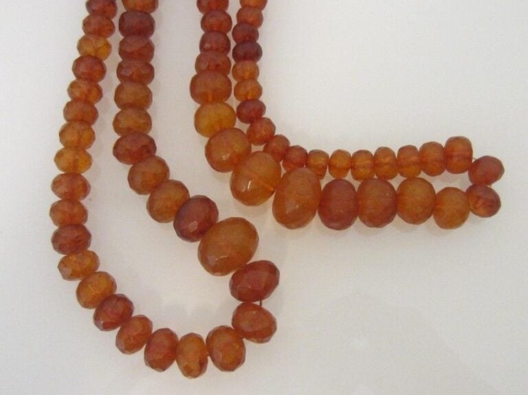 Deux longs COLLIERS composés de perles d'ambre facettées, en chut