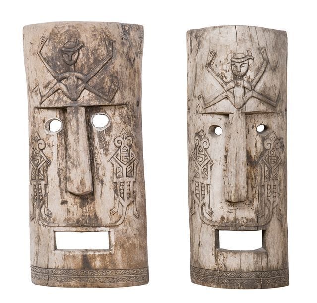Deux masques en bois sculpté et gravé de crocodiles stylisés et d'un personnage sur le fron