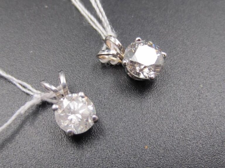 DEUX PENDENTIFS en or gris (585 millièmes) 14 carats chacun serti d’un diamant taille brillant, pesant respectivement 0,6 carat et 0,9 carat             Poids brut : 0,9 g