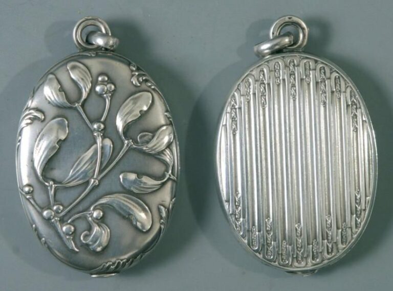 Deux pendentifs ovales en argent à double miroir, l'un à motif Art Nouveau de branches de gu