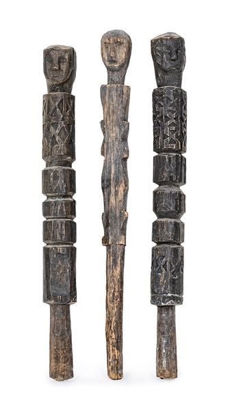 Deux piquets en bois sculpté surmontés de têtes anthropomorphe