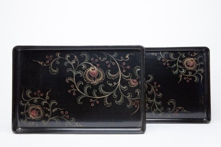 Deux plateaux laqués noirs à décor floral, le plus petit rentrant dans le plus gran