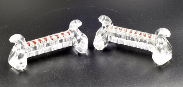 Deux porte-couteaux à pieds rocaille en cristal taillé orné d'une torsade rouge, blanche et vert