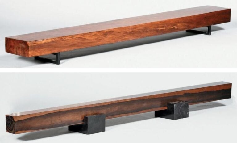 Deux poutres de bois exotique de largeurs différentes formant table basse sur piétement bas fixé en arceau en métal tubulaire noirc