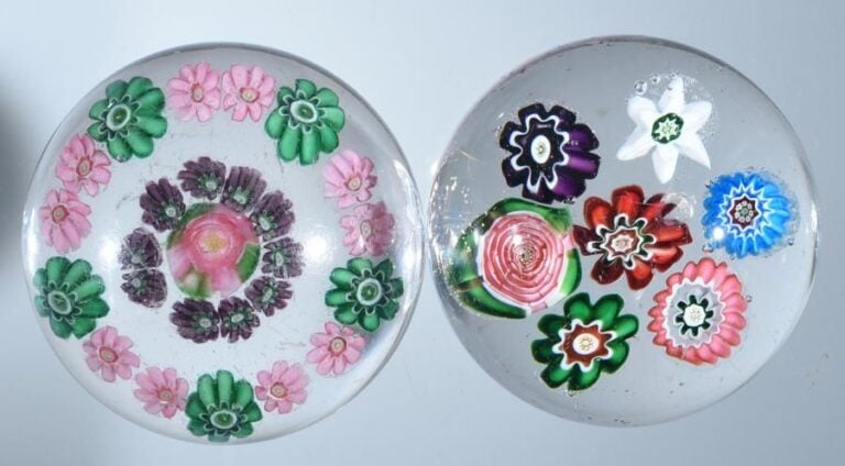 Deux presse-papiers: 1°) Presse-papiers à motif de deux cercles, l'un composé de dix bonbons roses et cinq bonbons verts, le second de dix bonbons violets autour d'un rose de Clichy rose et verte (qqs usures d'usage