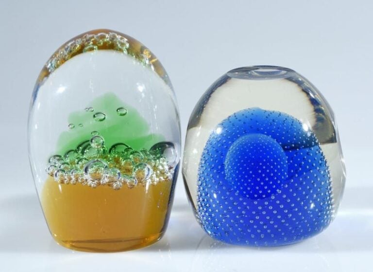 Deux presse-papiers ovoïdes, l'un à décor de bulles sur fond ambré, le second à décor de fines bulles organisées sur fond ble