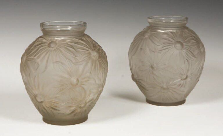 Deux vases à corps ovoïde et col annulaire Epreuves en verre soufflé moulé blanc, satiné mat, à décor de dahlias Signé Hau