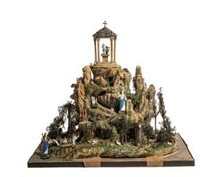 Diorama représentant un rocher surmonté d’un petit temple avec un amour en verre filé de Nevers, au pied d’un la