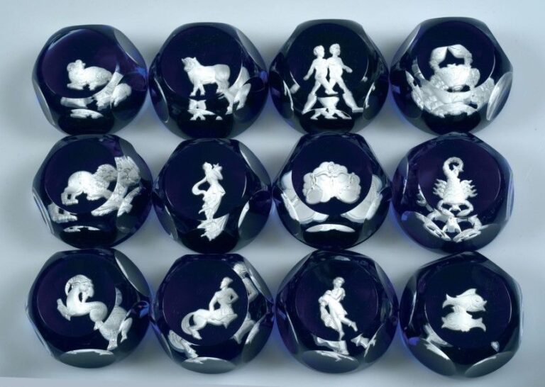 Douze presse-papiers à fond bleu translucide orné chacun d'un des douze signes du zodiaqu