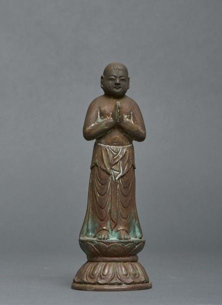Effigie en bronze de Bouddha Sakyamuni, debout sur un double lotus, les mains croisées devant la poitrin