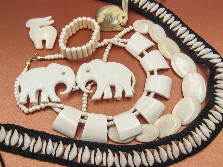 Ensemble «Afrique»: ceinture coquillages, deux colliers façon ivoire, boucle de ceinture à deux éléphants, deux broches anilaux, bracelet articulé façon ivoir