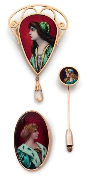 ENSEMBLE comprenant deux BROCHES et une ÉPINGLE à cravate en or jaune (750 millièmes) orné de émaux de Limoges peints à motifs de profils de femm