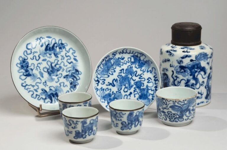 Ensemble comprenant quatre sorbets, un pot à thé et deux coupelles en porcelaine à décor en bleu sous couverte de chimères jouant parmi les ruban