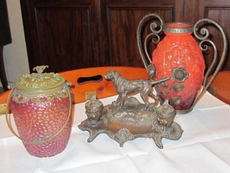Ensemble comprenant : un encrier en régule, un seau à biscuits, un vase en verre orange à anses à enroulements et motif floral en fer forgé