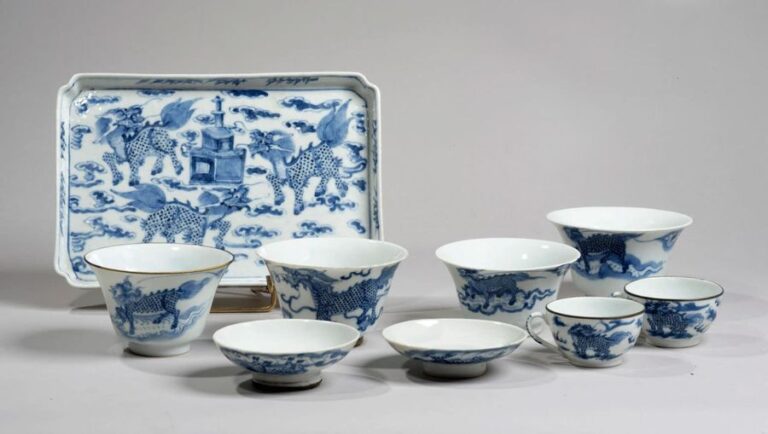 Ensemble comprenant un plateau rectangulaire, quatre petits bols et deux tasses en porcelaine à décor en bleu sous couverte de qilin parmi les nuée
