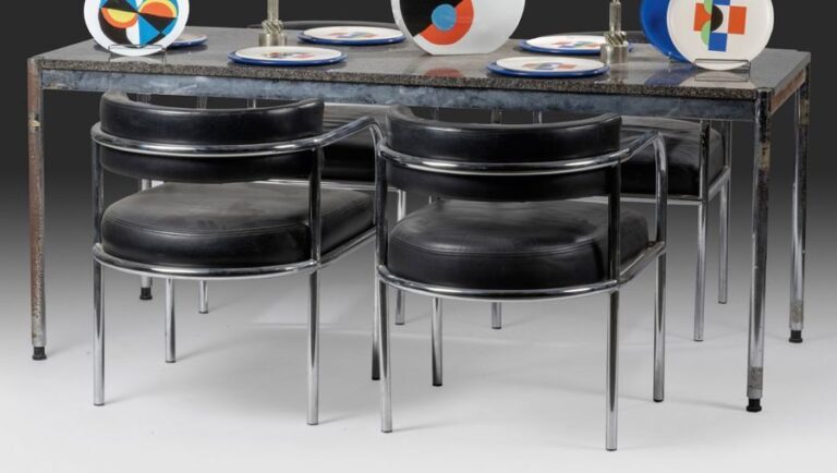 Ensemble de bureau composé d'une table à structure en métal chromé tubulaire garnie d'un plateau de marbre et de quatre fauteuils à dossier suspendu et assise garnie de cuir noir à structure en épais tubes de métal chrom