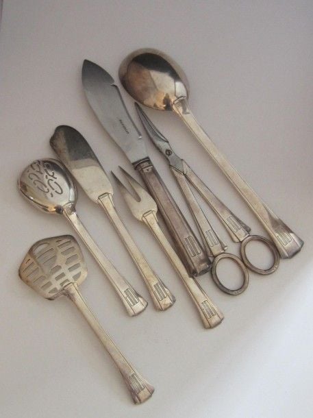 ENSEMBLE DE SEPT PIÈCES: cuillère, couteau, ciseaux à raisin, service à bonbons en argent uni, les spatules légèrement évasée