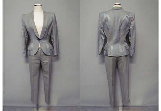 ENSEMBLE en lainage pied de poule gris souris, noir et ciment rehaussé d'empiècements géométriques en flanelle et satin, VESTE cintrée à col châle s'attachant par un bouton, poignets fendus, deux poches à rabat, PANTALON cigarette (T38) (mini couture décousue sur manche droite)