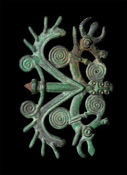 ÉPINGLE AUX CHIMÈRES Sommet d'épingle formé de deux chimères ailées, cornues, affrontées de part et d'autre d'un axe et dont les ailes, hérissées de pointes, sont bordées de volute