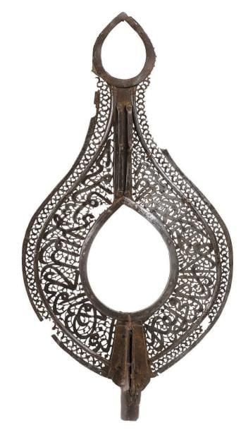 Étendard - Alam Acier repercé Iran, XVIIe-XVIIIe siècle Hauteur: 74; Largeur: 33 cm Cet Alam en forme de mandorle présente un décor épigraphique ajouré correspondant à l'inscription coranique partielle 9