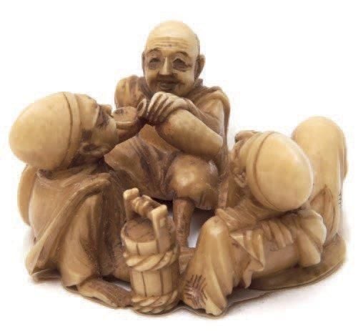 EXCEPTIONNEL NETSUKE en ivoire représentant trois hommes joyeux assis par terre et en train de boir