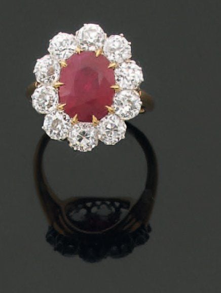 Exceptionnelle BAGUE « marguerite » en or jaune et or gris serti d'un rubis ovale entouré de dix diamants taille ancienn