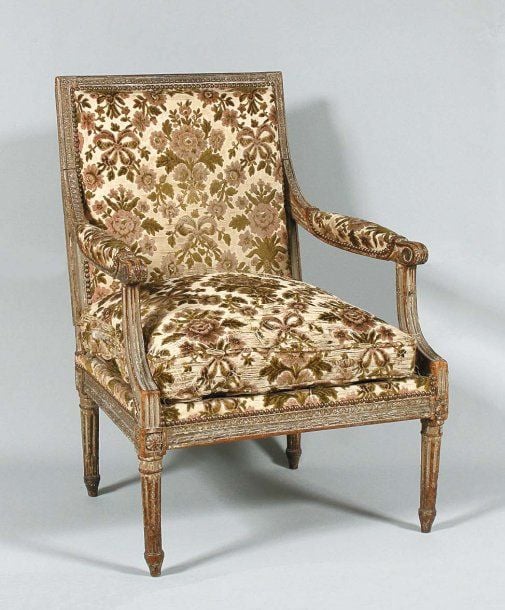 Fauteuil à dossier plat, en bois richement sculpté et laqué gris à encadrement de palmette