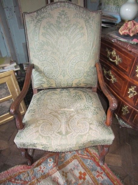 Fauteuil à dossier plat en noyer mouluré et sculpté de palmettes, recouvert de velours ver