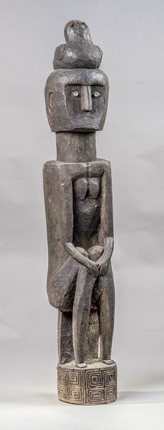 Femme assise en bois sculpté, les mains jointes sur les genoux, supportant un oiseau sur la têt