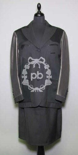 Femme (automne-hiver 1993/94, collection "Les rabbins chic") TAILLEUR en crêpe de laine noir à fines rayures blanches, veste agrémentée d'empiècements noirs et de manches longues en taffetas acier, col cranté sur simple boutonnage recouvert, rappel aux poignets, cinq poches passepoilées, fente dos, jupe droite (griffe noire, graphisme vert) (T42 it)