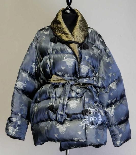 Femme (automne-hiver 1994/95, collection "Le Grand Voyage") MANTEAU 3/4 réversible garni de duvet d'oie en jacquard ardoise et ciment d'un côté figurant des têtes de taureaux et satin vert bouteille de l'autre, court col châle et parementures rebrodés marron glacé, rappel sur les poignets à revers, boutonnage brandebourgs en passementerie noire, deux poches dans les coutures, CEINTURE-LIEN (T42 it) (mini fils tirés) Bibliographie: modèles similaires reproduits
