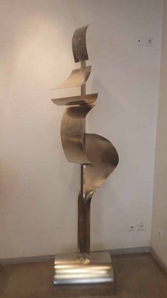 Femme galbée Sculpture en assemblage de tôle formée martelée et nickelée fixation soudures Montée sur un socle et tournant sur son axe H (socle inclus): 223 cm - l (maximale): 50 cm - P (maximale): 37 cm