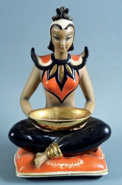 Femme orientale accroupie sur un coussin et tenant une coupe doré